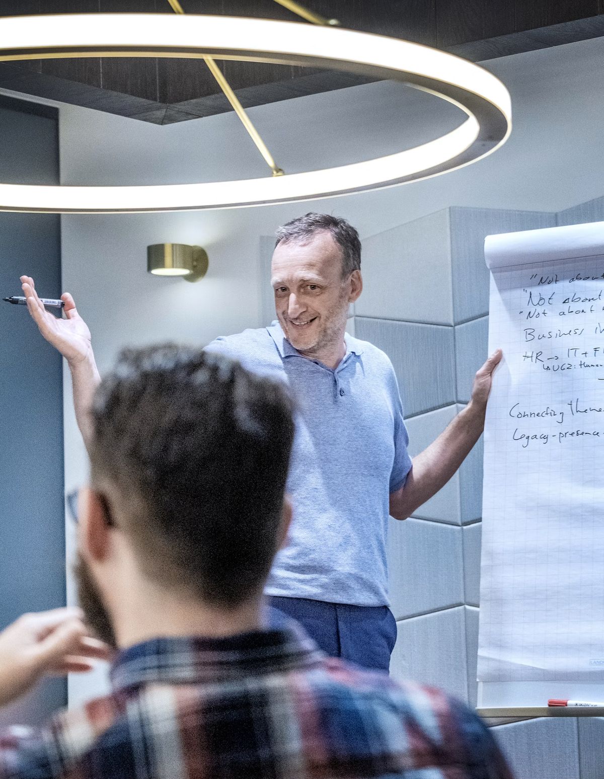 Tim Woodman leading a workshop, gesturing beside a flipchart