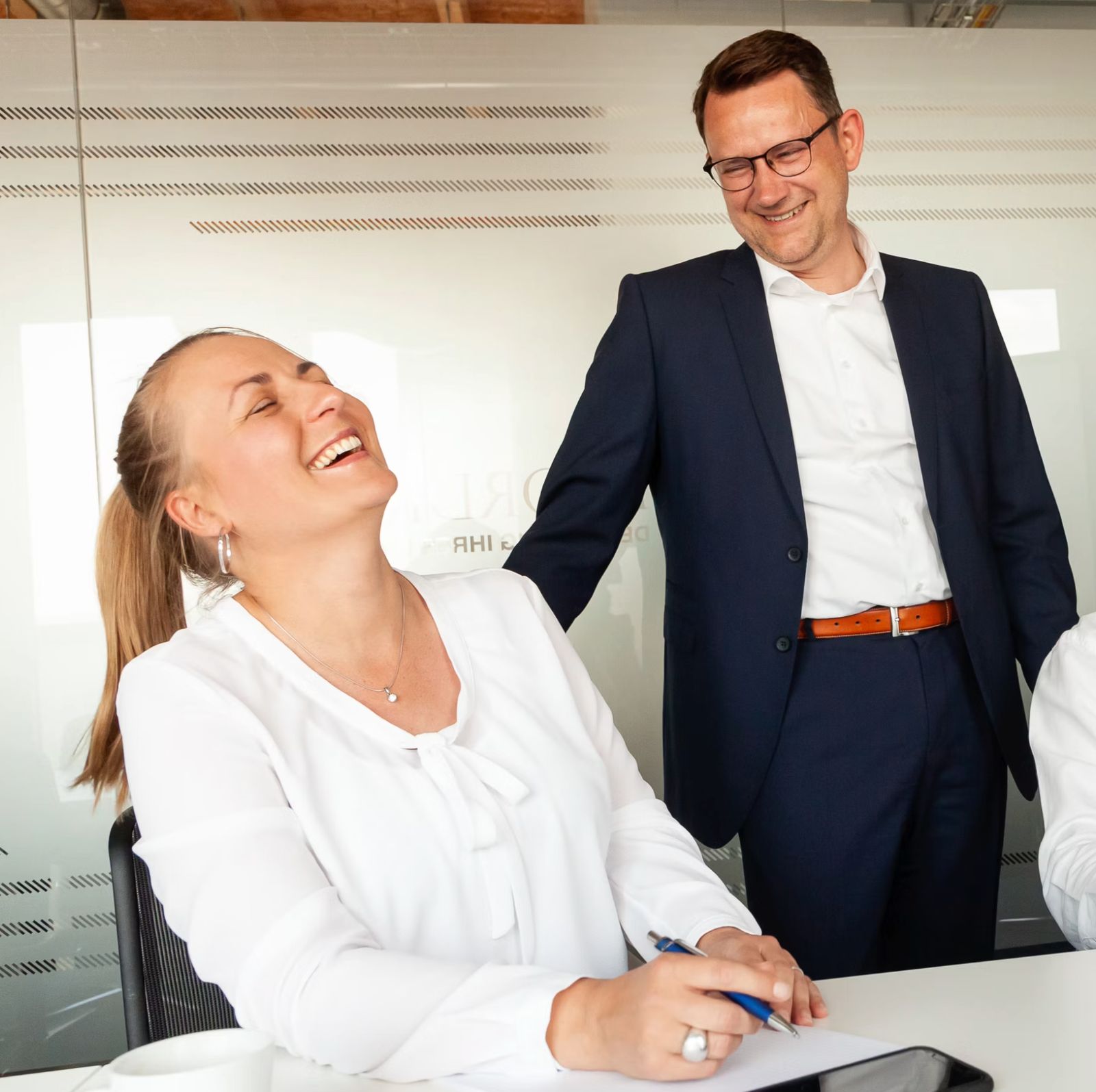 A manager and a team member laughing together in a meeting